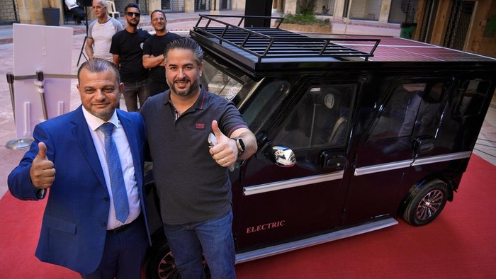 Pria di Lebanon Ciptakan Mobil Hybrid untuk Hadapi Krisis Energi Lebanese industrialist Hisham Houssami, left, and Lebanese caretaker Minister of Economy and Trade Amin Salam, gesture as they stand next to a hybrid car called Lira, or Pound, near the Ministry of Economy in downtown Beirut, Lebanon, Saturday, July 8, 2023. Houssami started the production of the car that is powered by electricity and solar energy amid rising cost of fuel as Lebanon sinks in its worst economic and financial crisis in its modern history. The Lebanese pound has lost more than 95% of its value since the meltdown began in October 2019. (AP Photo/Bilal Hussein)