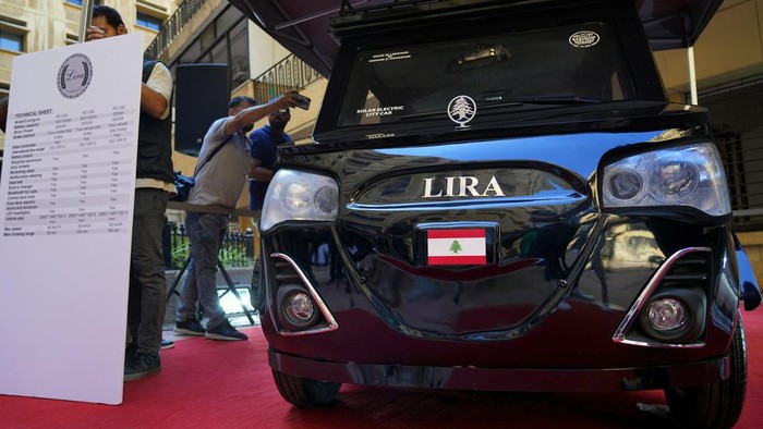 Lebanese industrialist Hisham Houssami, left, and Lebanese caretaker Minister of Economy and Trade Amin Salam, gesture as they stand next to a hybrid car called Lira, or Pound, near the Ministry of Economy in downtown Beirut, Lebanon, Saturday, July 8, 2023. Houssami started the production of the car that is powered by electricity and solar energy amid rising cost of fuel as Lebanon sinks in its worst economic and financial crisis in its modern history. The Lebanese pound has lost more than 95% of its value since the meltdown began in October 2019. (AP Photo/Bilal Hussein)