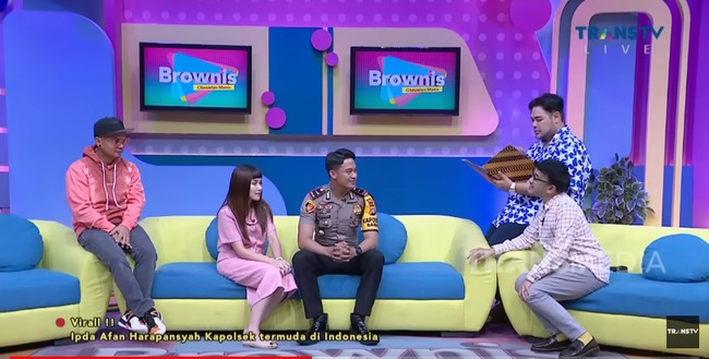 Ipda Afan Harapansyah menjadi sorotan karena dirinya menjadi Kapolsek termuda di Indonesia. Kini sosok Afan kembali viral usai tampil di televisi karena parasnya yang disebut ganteng. Ipda Mohamad Harapansyah menjadi bintang tamu di program acara Brownis Trans Tv. Dia mengatakan saat ini dirinya aktif sebagai Kapolsek Baras, Kabupaten Pasangkayu, di Sulawesi Barat. Pria yang akrab disapa Afan ini lahir di Bogor, 16 Juni 1999. Setelah tamat SMA, dia kemudian mendaftar di Akademi Kepolisian (Akpol) dan lulus tahun 2020. Setelah itu, Ipda Afan ditempatkan di Polda Sulbar. Foto: Dok. Youtube Trans Tv.