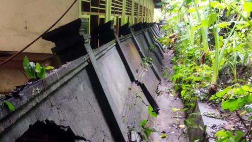 Tembok penyengker yang ada di SDN 5 Antiga yang terletak di Banjar Dinas Ketug, Desa Antiga, Kecamatan Manggis, Kabupaten Karangasem ambruk dan menimpa 4 ruang kelas akibat hujan deras Minggu (9/7/2023).