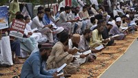 Sejumlah warga membaca Al-Quran selama aksi unjuk rasa. (AP Photo/Fareed Khan)  