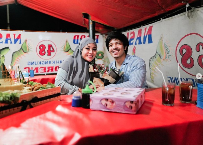 Aurel dan Atta merayakan momen ulang tahun di warung tenda pinggir jalan. Keduanya berpose di sebuah warung nasi uduk dan seafood. Foto: Instagram @attahalilintar