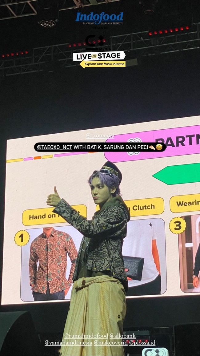 Alhasil Taeyong NCT memilih kemeja batik, peci, dan sarungnya sendiri. Dia pun dibantu MC Indra Herlambang mengenakan sarung dengan benar. Foto: Instagram