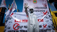 Salah seorang massa mengenakan APD hazmat.  