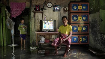 Karya Giacomo dOrlando. Sebuah foto seorang pria dan anak laki-laki di ruang tamu yang tergenang air di Jawa, Indonesia, menarik perhatian juri. Ini adalah bagian dari proyek jangka panjang oleh fotografer Giacomo dOrlando untuk mendokumentasikan kenaikan permukaan laut dan bagaimana orang beradaptasi untuk bertahan dari dampak perubahan iklim. Foto: photocrowd