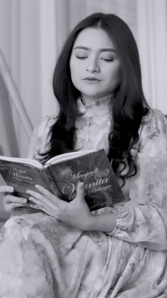 Tampak ia muncul dalam balutan maxi-dress motif floral dengan kerah bergaya victorian. Nathalie direkam sambil berpose buka pintu, kemudian duduk di ayunan sambil membaca buku ‘Menjadi Wanita Paling Bahagia’. (Foto: Instagram/@nathalieholscher)