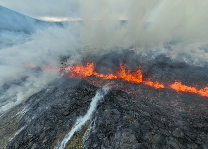 Smoke billows and lava flows after the eruption of a volcano, on the Reykjanes peninsula, near the capital Reykjavik, in southwest Iceland, July 10, 2023, in this picture obtained from social media. Juergen Merz - Glacier Photo Artist/via REUTERS  THIS IMAGE HAS BEEN SUPPLIED BY A THIRD PARTY. MANDATORY CREDIT. NO RESALES. NO ARCHIVES.