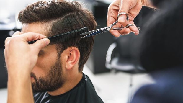 quiff undercut Close up of hairdresser arms cutting and combing male hair