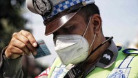 Pak polisi tampak serius mengecek SIM salah satu pengendara.  
