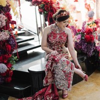 Calon mempelai wanita, Tina Toon, tampil cantik dalam balutan gaun cheongsam merah marun yang dipenuhi aksen bordir. Gaunnya dilengkapi jubah bermotif burung phoenix dan bunga. Foto: Instagram @tinatoon101