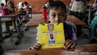Seorang anak dengan gembira menunjukan tanda pengenal dirinya saat mengikuti MPLS.  