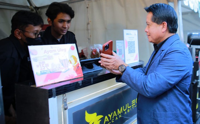 Direktur Utama BSI Hery Gunardi (tengah) saat menunjukan bukti transaksi menggunakan QRIS saat berbelanja produk UMKM rekanan BSI Area Malang di acara Mata Najwa on Stage di Universitas Muhammadiyah Malang (UMM), Jawa Timur pada Rabu (12/7/2023).