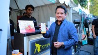 Direktur Utama BSI Hery Gunardi menunjukan bukti transaksi menggunakan QRIS saat berbelanja produk UMKM rekanan BSI area Malang, Rabu (12/7/2023). 