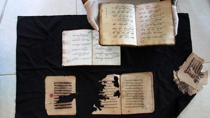 Petugas memperlihatkan kitab yang rusak dan yang masih utuh saat proses digitalisasi manuskrip di Padang, Sumatera Barat, Rabu (12/7/2023). Digitalisasi manuskirp yang dilakukan Lembaga Surau Intellectual for Conservation (SURI) tersebut sebagai upaya penyelamatan khazanah budaya dan pelestarian warisan leluhur yang berisikan kearifan lokal dengan tujuan merawat fisiknya serta perlindungan terhadap informasi yang terkandung di dalam naskah kuno itu. ANTARA FOTO/Muhammad Arif Pribadi/nym.
