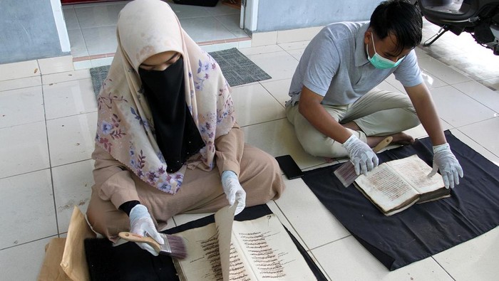 Petugas memperlihatkan kitab yang rusak dan yang masih utuh saat proses digitalisasi manuskrip di Padang, Sumatera Barat, Rabu (12/7/2023). Digitalisasi manuskirp yang dilakukan Lembaga Surau Intellectual for Conservation (SURI) tersebut sebagai upaya penyelamatan khazanah budaya dan pelestarian warisan leluhur yang berisikan kearifan lokal dengan tujuan merawat fisiknya serta perlindungan terhadap informasi yang terkandung di dalam naskah kuno itu. ANTARA FOTO/Muhammad Arif Pribadi/nym.