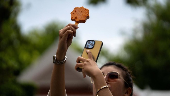 Es Krim Bentuk Ubin Kuil Jadi Jajanan Unik di Wat Arun Thailand People take pictures of ice cream shaped like tiles of the famous Wat Arun temple, or Temple of Dawn, in Bangkok, Thailand July 8, 2023. REUTERS/Athit Perawongmetha