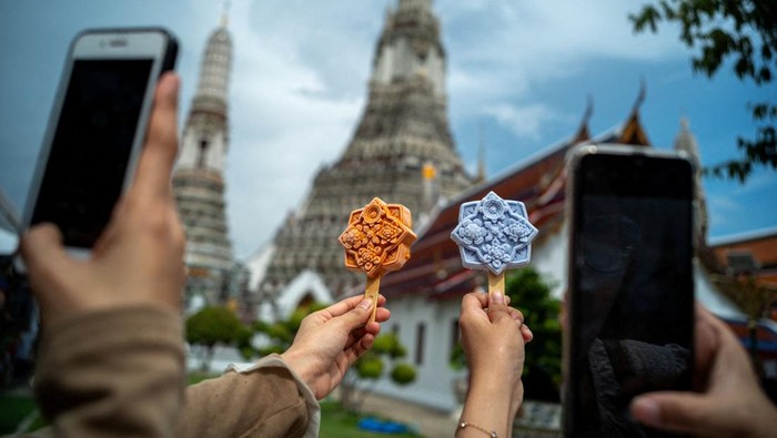 Es Krim Bentuk Ubin Kuil Jadi Jajanan Unik di Wat Arun Thailand People take pictures of ice cream shaped like tiles of the famous Wat Arun temple, or Temple of Dawn, in Bangkok, Thailand July 8, 2023. REUTERS/Athit Perawongmetha