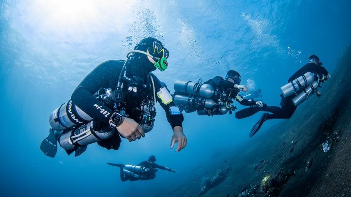 Diving dengan tabung oksigen di samping tubuh diver