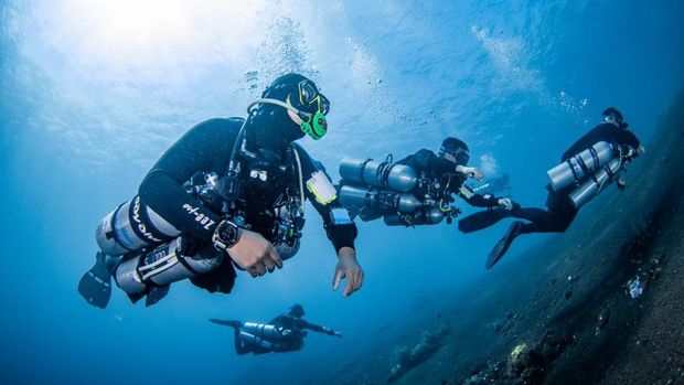 Diving dengan tabung oksigen di samping tubuh diver