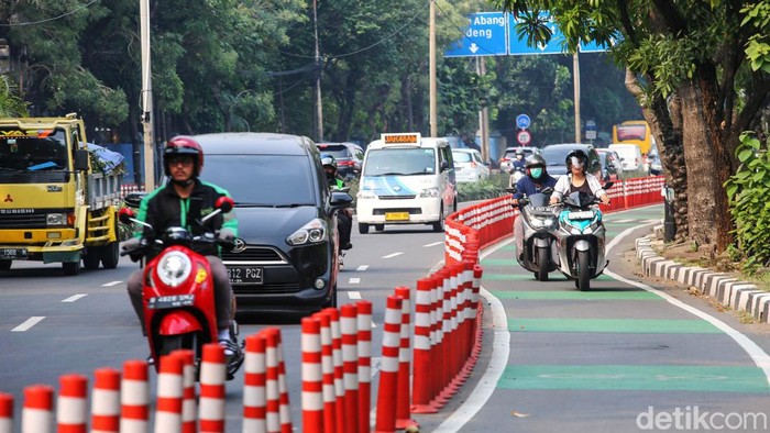 Sejumlah pengendara sepeda motor dan mobil melintasi jalur sepeda di jalan Penjernihan, Jakarta, Rabu (12/7/2023). Jalur sepeda yang kini makin terabaikan akhirnya diserobot tidak hanya oleh pengendara motor, tetapi juga oleh pengendara mobil.
