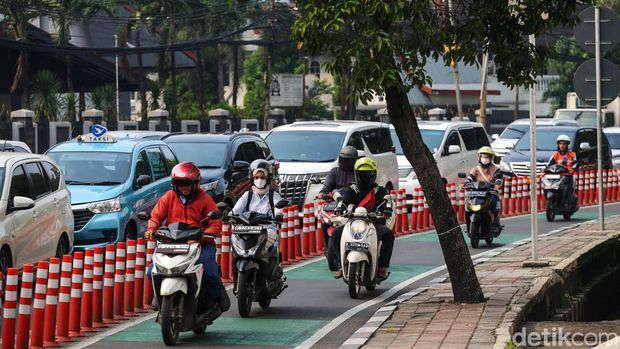 Sejumlah pengendara sepeda motor dan mobil melintasi jalur sepeda di jalan Penjernihan, Jakarta, Rabu (12/7/2023). Jalur sepeda yang kini makin terabaikan akhirnya diserobot tidak hanya oleh pengendara motor, tetapi juga oleh pengendara mobil.