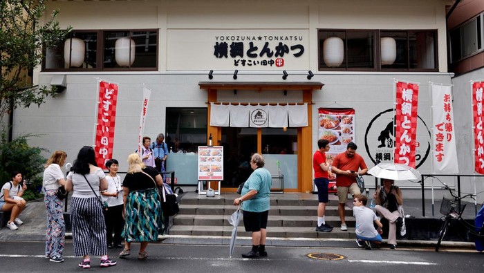 Unik, Resto Jepang Ini Tawarkan Santap Makan Sambil Nonton Sumo Tourists from abroad wait for Yokozuna Tonkatsu Dosukoi Tanaka, a sumo wrestling themed restaurant to open, in Tokyo, Japan June 30, 2023. REUTERS/Issei Kato