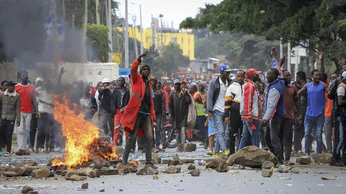 Demo Biaya Hidup di Kenya Berujung Bentrok dengan Polisi, 6 Orang Tewas A protester burns tyres to block the road in the Kibera neighborhood of Nairobi, Kenya, Wednesday, July 12, 2023. Anti-government protesters are demonstrating in a number of Kenyan cities against newly imposed taxes and the cost of living. (AP Photo/Samson Otieno)