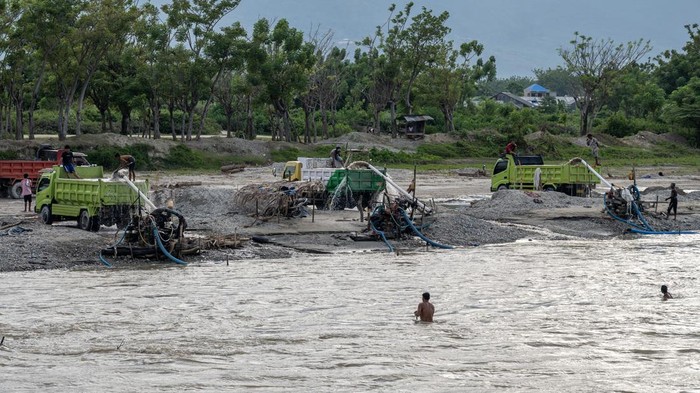 Melihat Pertambangan Rakyat di Sigi Sulawesi Tengah Pekerja meratakan pasir yang disedot dari sungai ke atas truk di kasawan pertambangan rakyat galian C di Desa Sunju, Sigi, Sualwesi Tengah, Rabu (12/7/2023). Untuk mengatasi pendangkalan sungai yang terus terjadi di wilayah itu dan menekan beban biaya pengerukan, Pemerintah setempat membuka kawasan itu sebagai wilayah pertambangan rakyat galian C berupa pasir dan kerikil sekaligus untuk menambah sumber pendapatan daerah melalui retribusi. ANTARA FOTO/Basri Marzuki/foc.
