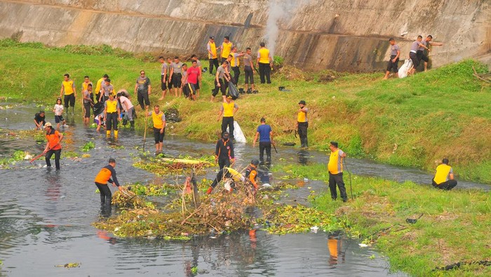 Sejumlah anggota Polisi bersama relawan dan warga membersihkan sampah di Sungai Gelis, Kudus, Kamis (13/7/2023). Aksi bersih sampah serentak bersama Polri tersebut untuk mengurangi tumpukan sampah dan enceng gondok yang menyumbat dan mencemari sungai, sekaligus upaya mengajak masyarakat untuk menjaga kebersihan lingkungan dengan tidak membuang sampah ke sungai. ANTARA FOTO/Yusuf Nugroho/hp.