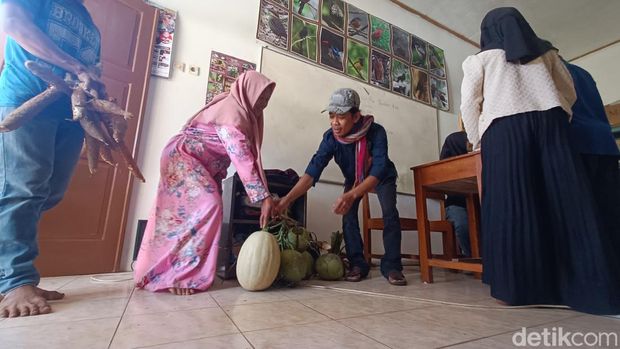 Wali murid membawa hasil bumi untuk mendaftar sekolah di MTs Pakis, Desa Gununglurah, Kecamatan Cilongok, Banyumas, Kamis (13/7/2023).