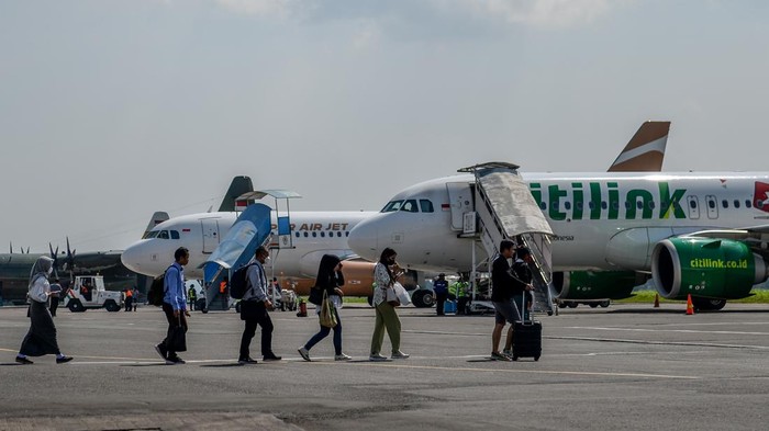 Siap-siap Penerbangan Dari Bandara Husein Bakal Pindah ke Kertajati Calon penumpang berjalan menuju pesawat di Bandara Husein Sastranegara, Bandung, Jawa Barat, Kamis (13/7/2023). Presiden Joko Widodo menyatakan, penerbangan dari Bandara Husein Sastranegara akan beralih ke Bandara Internasional Kertajati mulai Oktober 2023 seiring dengan rampungnya infrastruktur penunjang yaitu Jalan Tol Cisumdawu. ANTARA FOTO/Raisan Al Farisi/aww.