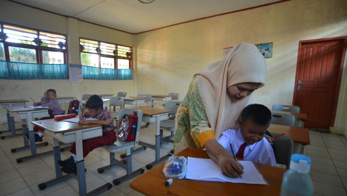 Tiga murid mengikuti kegiatan belajar di SDN 23 Lolong Padang, Sumatera Barat, Kamis (13/7/2023). Awal tahun ajaran baru, murid kelas 1 di sekolah tersebut hanya berjumlah tiga orang, meliputi dua murid baru dan satu murid tinggal kelas, akibat adanya kebijakan sistem zonasi pada Penerimaan Peserta Didik Baru (PPDB) karena di sana terdapat SDN lain yang berdekatan dan lokasi sekolah yang dekat dengan pantai.  ANTARA FOTO/Iggoy el Fitra/hp.