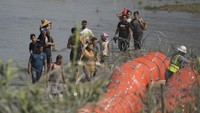 Migran yang mencoba memasuki AS dari Meksiko mendekati lokasi tempat para pekerja memasang pelampung besar untuk digunakan sebagai penghalang perbatasan. Pembatas apung ini dirancang untuk bisa dipindah dan ditambah guna menutupi daerah sepanjang sungai jika dibutuhkan.