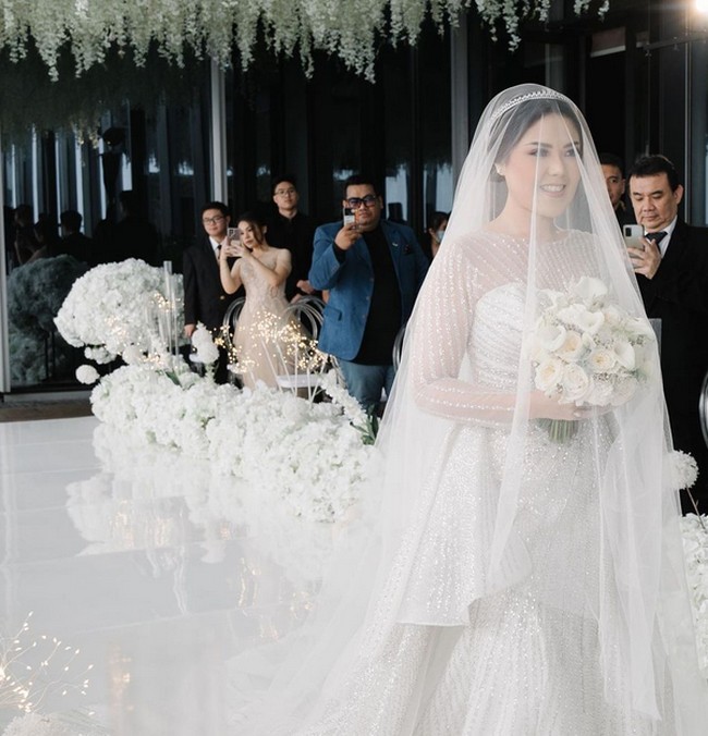 Dalam prosesi pemberkatan, Tina tampil menawan dengan. gaun putih lengan panjang lengkap dengan veil. Foto: dok. Instagram/@tinatoon101