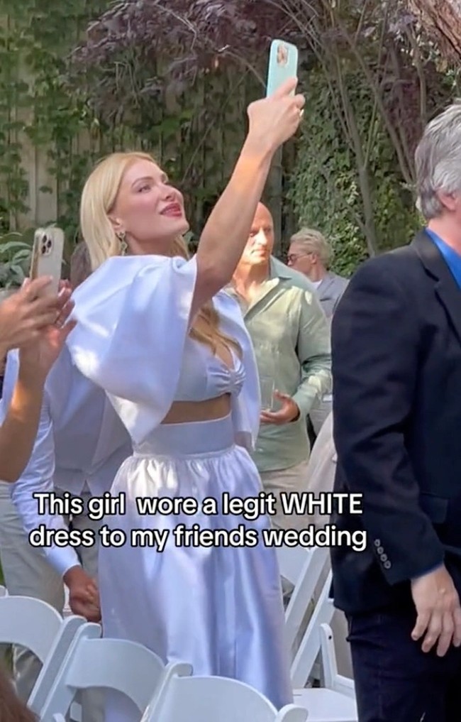 Dalam sebuah video viral yang sudah dihapus, pengunggah Kristina Drobach menampilkan gaya sesama tamu undangan di pesta pernikahan teman. Adalah Lana Kaufman, wanita rambut pirang yang memakai setelan warna putih. Bajunya terlihat cantik tapi atasan berlengan balon dan rok A-line itu dianggap norak. Foto: TikTok