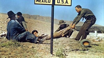 Petugas patroli Perbatasan Amerika Serikat menyeret seorang buronan melintasi perbatasan AS untuk mencegahnya melarikan diri ke Meksiko di 1920. Foto: History daily