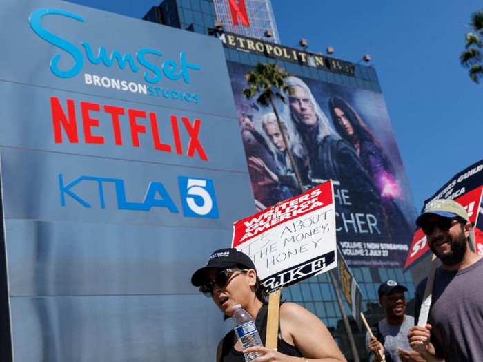 FILE PHOTO: Striking Writers Guild of America (WGA) members walk the picket line in front of Netflix offices as SAG-AFTRA union announced it had agreed to a last-minute request by the Alliance of Motion Picture and Television Producers for federal mediation, but it refused to again extend its existing labor contract past the 11:59 p.m. Wednesday negotiating deadline, in Los Angeles, California, U.S., July 12, 2023.   REUTERS/Mike Blake/File Photo