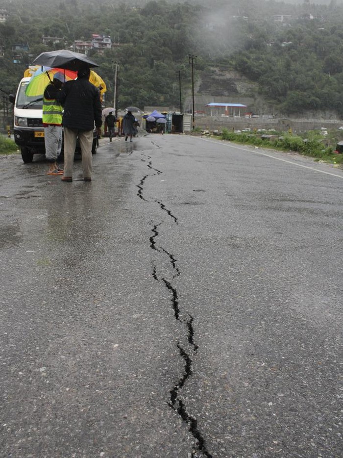 Jalanan di India Longsor Imbas Hujan Deras, Begini Penampakannya People walk through a a road that has developed cracks following heavy rains in Kullu District, Himachal Pradesh, India, Monday, July 10, 2023. Indiaβs weather agency has forecast more heavy rains in the north in the coming days. (AP Photo/ Aqil Khan)