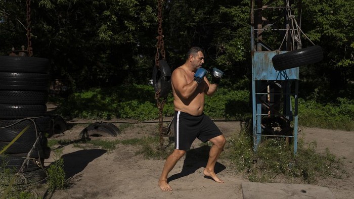 A man works out using equipment built with scrap metal at the Kachalka outdoor gym in Kyiv, Ukraine, Wednesday, July 12, 2023. The outdoor gym, located on Dolobetskyi island of the capital city, opened in 1966. (AP Photo/Jae C. Hong)