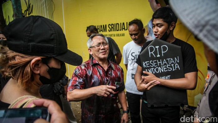 Massa menggelar aksi damai menolak UU Kesehatan yang baru disahkan. Sambil membawa payung, massa aksi di seberang kantor Kemenkes, Jakarta.
