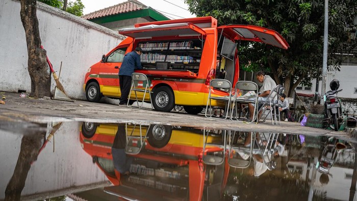 Warga membaca koran yang dipinjam dari Mobil Internet dan Perpustakaan Kewilayahan (Monika) di Alun-alun Selatan, Yogyakarta, Jumat (14/7/2023). Pengoperasian mobil perpustakaan keliling oleh Dinas Perpustakaan Kota Yogyakarta tersebut guna mempermudah akses masyarakat mendapatkan bahan bacaan bermutu secara gratis serta untuk menumbuhkan minat baca masyarakat. ANTARA FOTO/Andreas Fitri Atmoko/hp.
