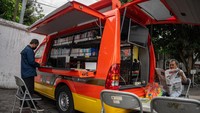 Warga membaca koran yang dipinjam dari Mobil Internet dan Perpustakaan Kewilayahan (Monika) di Alun-alun Selatan, Yogyakarta, Jumat (14/7/2023).  