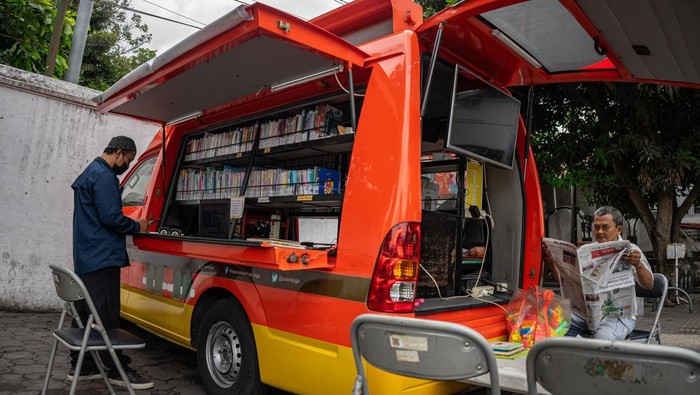 Mobil Internet dan Perpustakaan Keliling untuk Tumbuhkan Minat Baca Warga membaca koran yang dipinjam dari Mobil Internet dan Perpustakaan Kewilayahan (Monika) di Alun-alun Selatan, Yogyakarta, Jumat (14/7/2023). Pengoperasian mobil perpustakaan keliling oleh Dinas Perpustakaan Kota Yogyakarta tersebut guna mempermudah akses masyarakat mendapatkan bahan bacaan bermutu secara gratis serta untuk menumbuhkan minat baca masyarakat. ANTARA FOTO/Andreas Fitri Atmoko/hp.