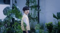 Trainee Korea bernama Jungmin terlihat sedang berada di antara tanaman-tanaman hijau yang membuatnya tampak mencolok dengan pakaian kuningnya. (Foto: dok. SM Entertainment)  