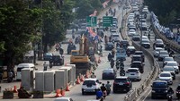 Pengendara melintas di dekat proyek pembangunan saluran air atau drainase di Jalan KH Abdullah Syafei, Jakarta, Jumat (14/7/2023).   