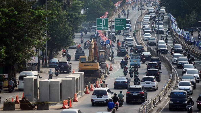 Pengendara melintas di dekat proyek pembangunan saluran air atau drainase di Jalan KH Abdullah Syafei, Jakarta, Jumat (14/7/2023). Pemkot Jakarta Selatan membangun drainase sepanjang 2.400 meter di empat titik yaitu Jalan Asem Baris Raya, Jalan KH Abdullah Syafei, Jalan Ciputat Raya-Jalan RA Kartini, dan Jalan Kalibata Timur sebagai upaya penanggulangan banjir di wilayah tersebut. ANTARA FOTO/Akbar Nugroho Gumay/tom.