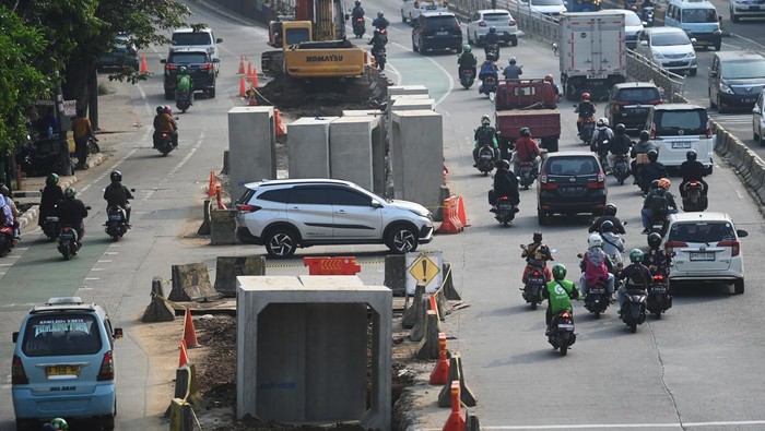 Potret Pembangunan Drainase di Tengah Jalan Jaksel Pengendara melintas di dekat proyek pembangunan saluran air atau drainase di Jalan KH Abdullah Syafei, Jakarta, Jumat (14/7/2023). Pemkot Jakarta Selatan membangun drainase sepanjang 2.400 meter di empat titik yaitu Jalan Asem Baris Raya, Jalan KH Abdullah Syafei, Jalan Ciputat Raya-Jalan RA Kartini, dan Jalan Kalibata Timur sebagai upaya penanggulangan banjir di wilayah tersebut. ANTARA FOTO/Akbar Nugroho Gumay/tom.