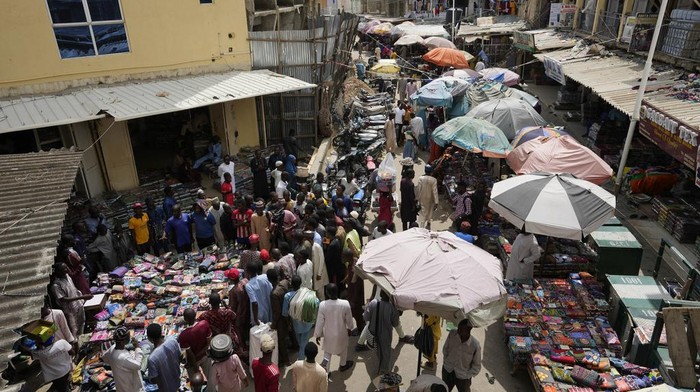 People shop at a market in Kano, Nigeria, Thursday, July 13, 2023. Nigerias President Bola Tinubu has announced his governments plan to pay $10 monthly to poor households to ease the growing hardship caused by the scrapping of subsidies that had reduced the cost of gasoline. (AP Photo/Sunday Alamba)