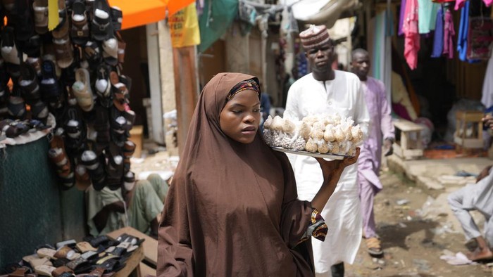 Subsidi BBM Dihapus, Presiden Nigeria Bakal Beri 'BLT' People shop at a market in Kano, Nigeria, Thursday, July 13, 2023. Nigeria's President Bola Tinubu has announced his government's plan to pay $10 monthly to poor households to ease the growing hardship caused by the scrapping of subsidies that had reduced the cost of gasoline. (AP Photo/Sunday Alamba)