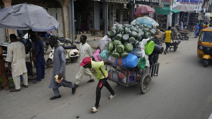 People shop at a market in Kano, Nigeria, Thursday, July 13, 2023. Nigeria's President Bola Tinubu has announced his government's plan to pay $10 monthly to poor households to ease the growing hardship caused by the scrapping of subsidies that had reduced the cost of gasoline. (AP Photo/Sunday Alamba)